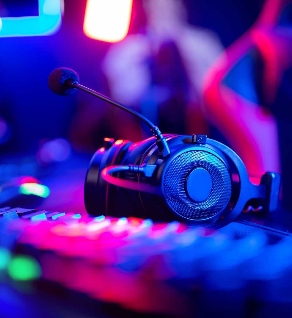 Headphones with microphone for video games and cyber esports on neon background of gaming monitor QTnet Image